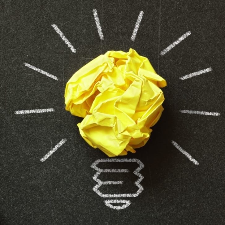 Crumpled paper with one crafted into a lightbulb.