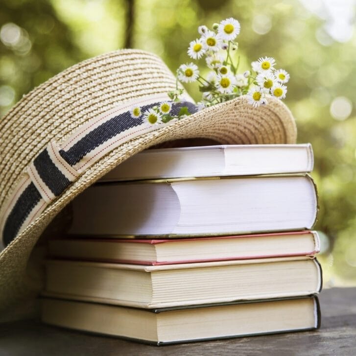 A hat rests on top of a stack of books.