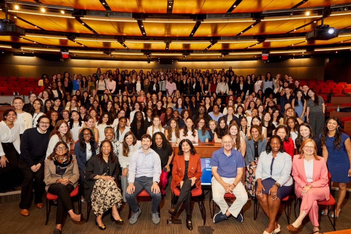 A large crowd primarily composed of women seated together in a large auditorium.