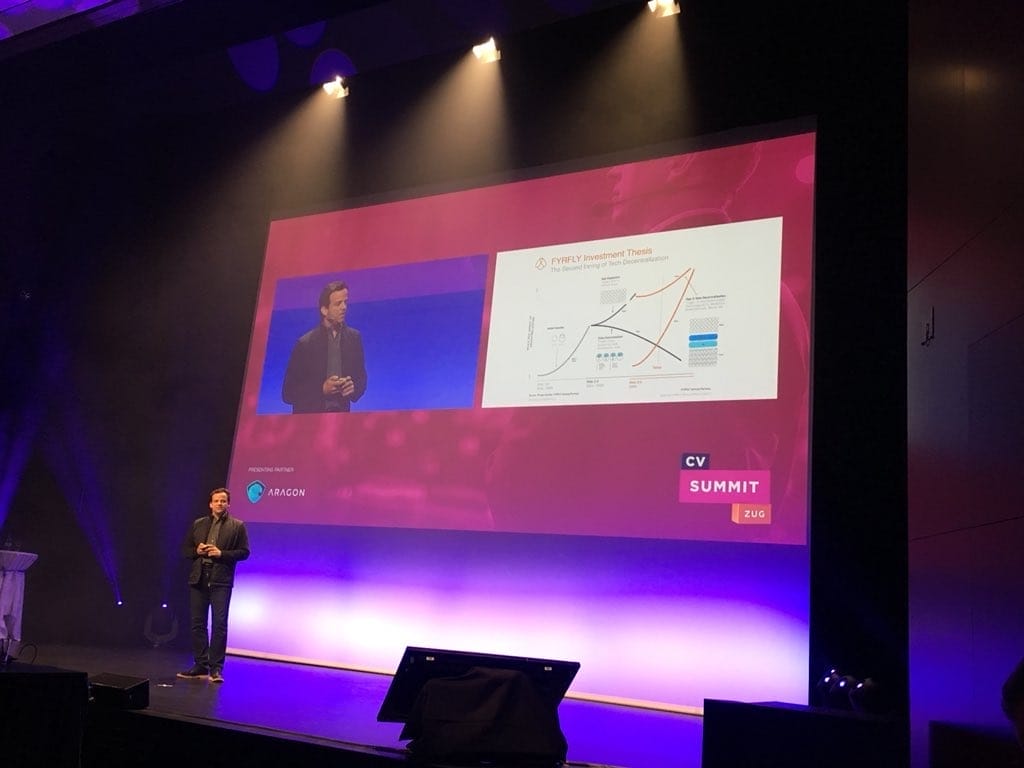 Man stands in front of projector on a stage