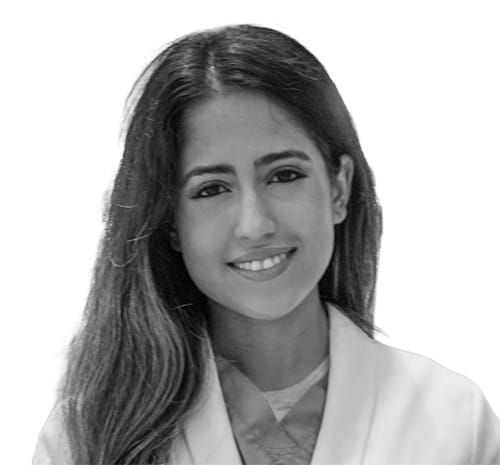 Headshot of a woman in a medical jacket and scrubs.