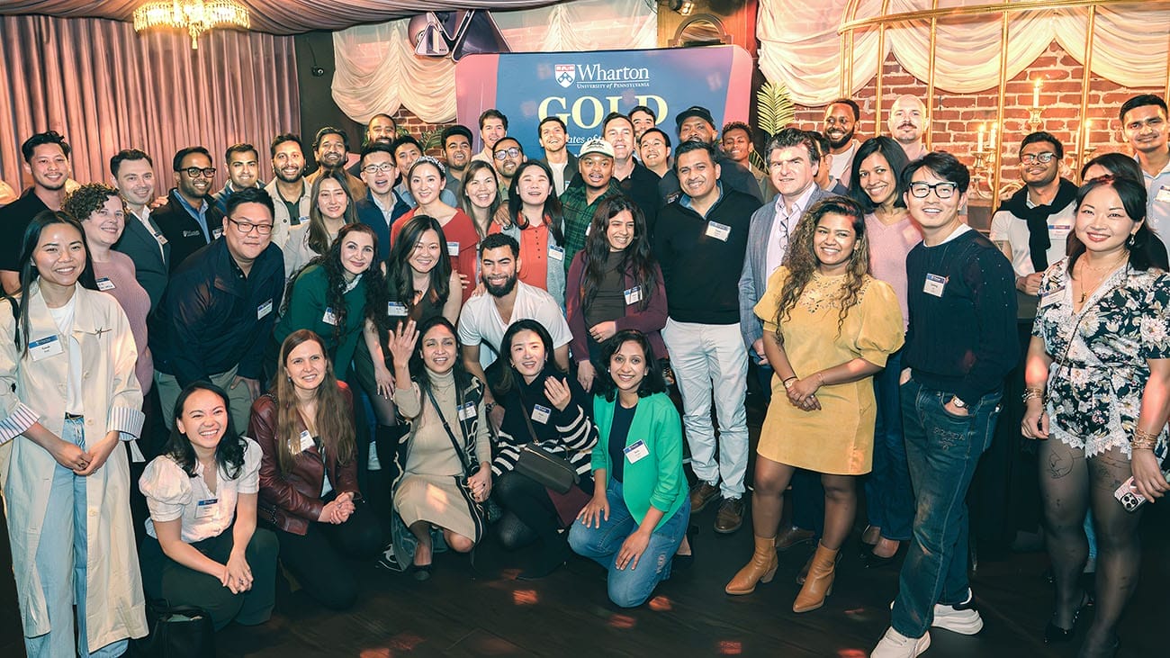 Dozens of people in casual attire pose for a photo at a networking event.